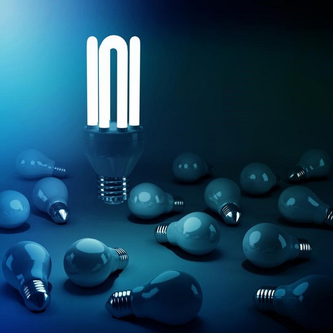 An energy-saving bulb lit above other dead bulbs.