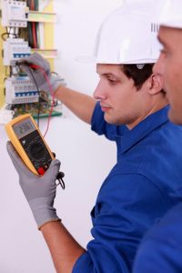 Electricians inspecting electrical circuit.